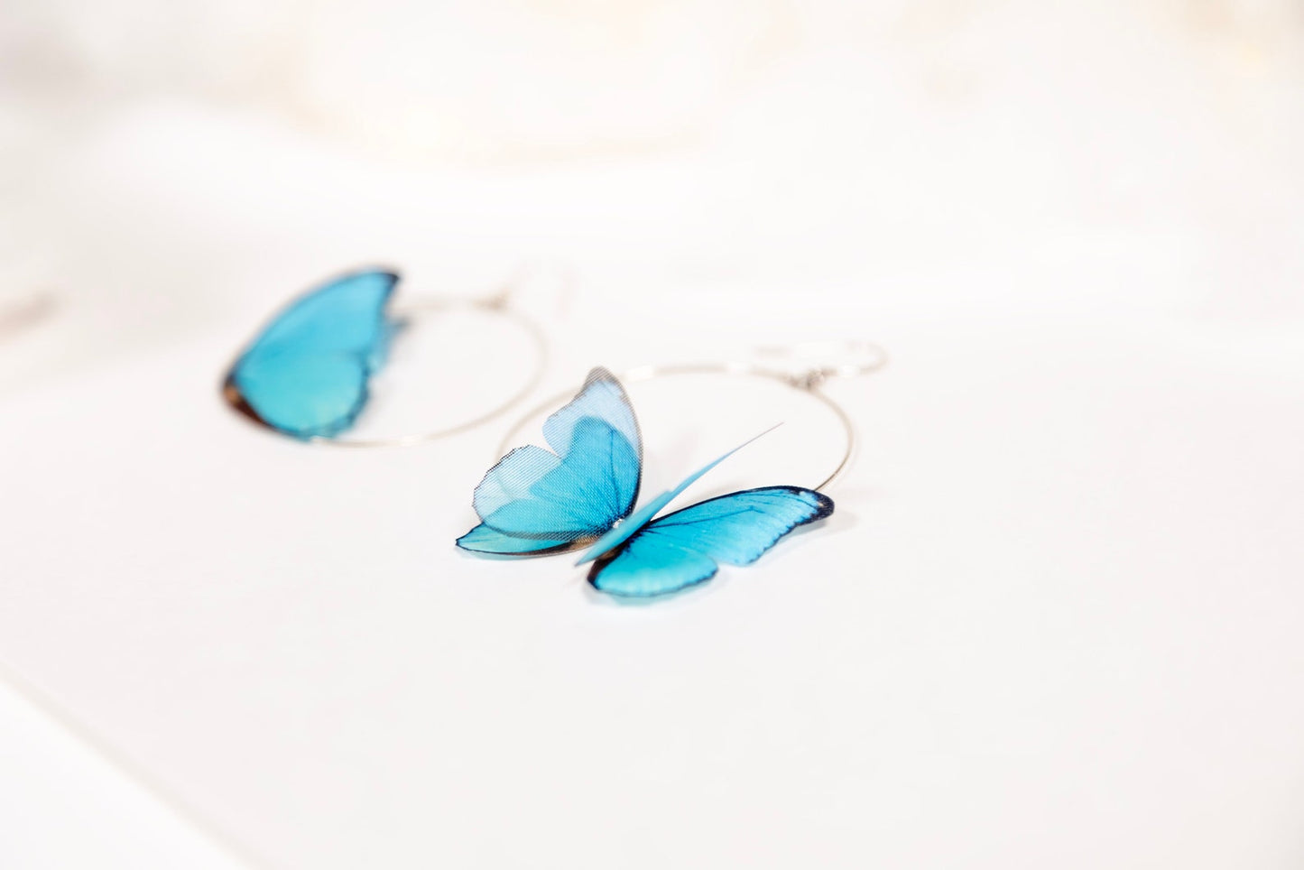 Close-up of Blue Butterfly Hoop Earrings Modeled on Ear