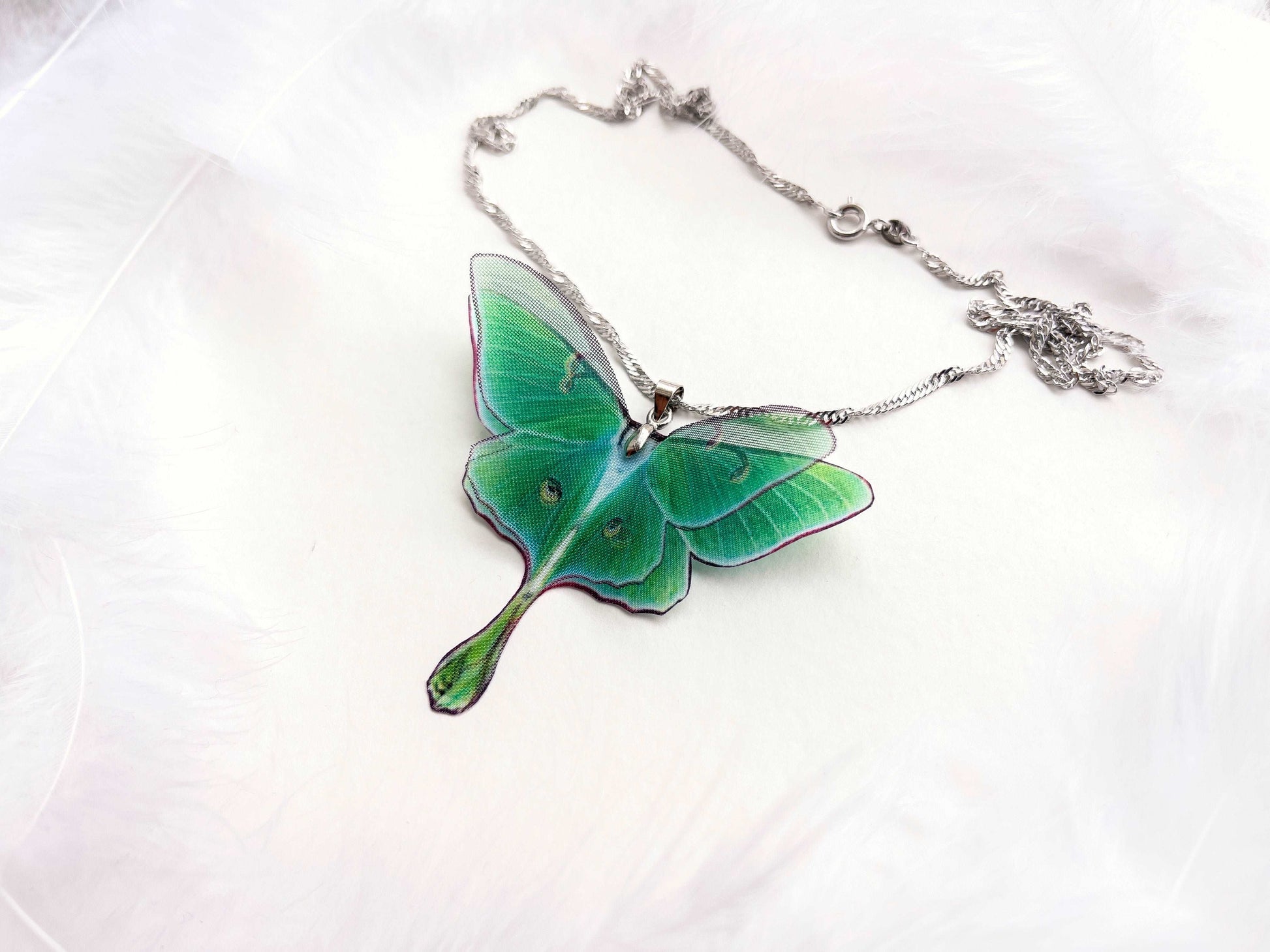 Close-up of the stunning green hues of the Green Lunar Moth Pendant - A calming and serene addition to your jewelry collection