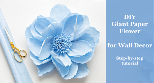 A step-by-step tutorail on how to create a giant crepe paper flower for wall decor, featuring blue petals and a circle base, with a pair of scissors and a flower on the left side of the image.
