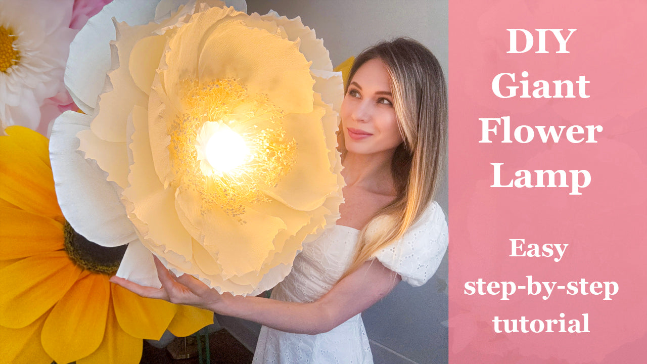 Alina Blossom holding a glowing DIY giant paper flower lamp made from crepe paper - step-by-step tutorial and downloadable template available on YouTube.