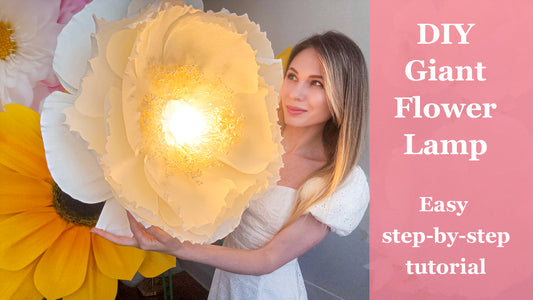 Alina Blossom holding a glowing DIY giant paper flower lamp made from crepe paper - step-by-step tutorial and downloadable template available on YouTube.