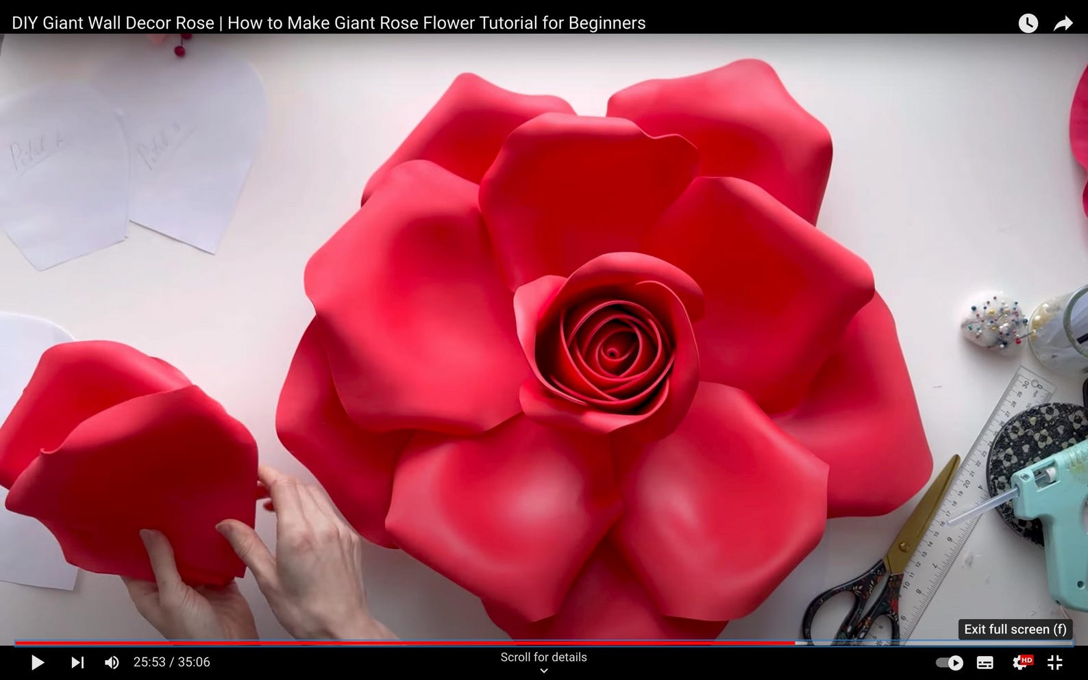 Red giant rose flower being assembled on a white surface with tools and materials.