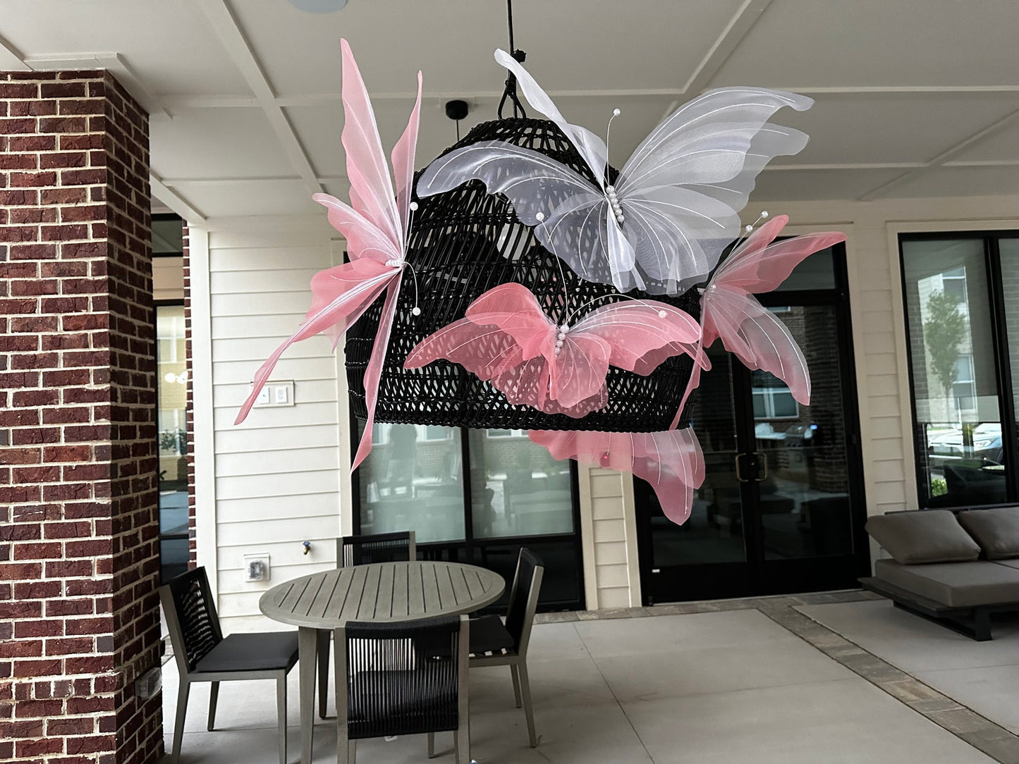 Butterfly-shaped chandelier hanging in a room with a table and chairs.