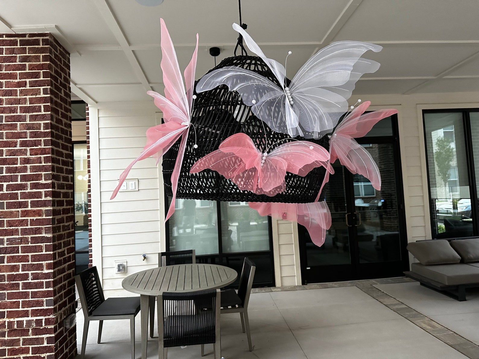 Butterfly-shaped chandelier hanging in a room with a table and chairs.