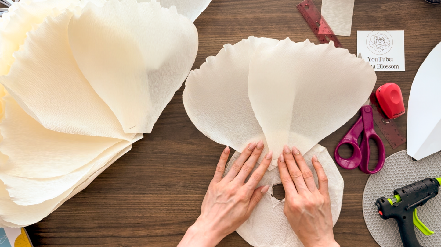 Gluing petals to circular base to create flower lamp