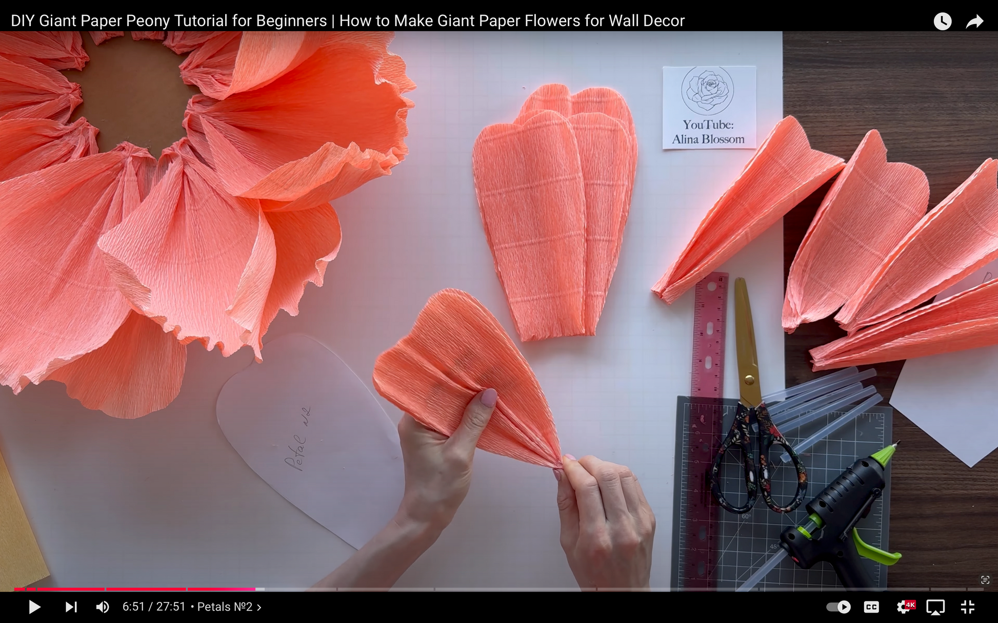 DIY Giant Paper Peony Tutorial for Beginners with paper flowers and tools on a table.