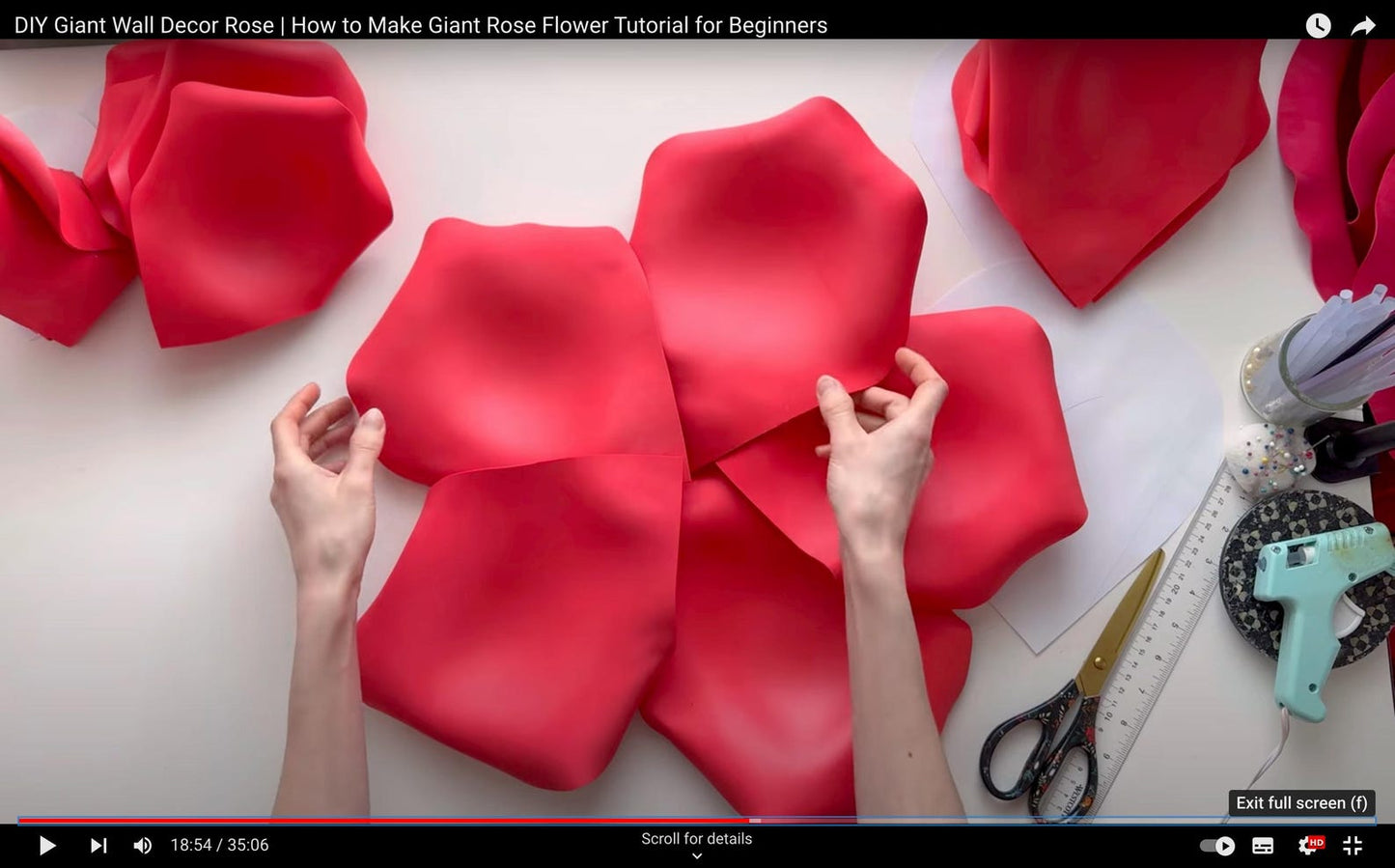 DIY Giant Rose Flower Tutorial for Beginners with red rose petals and hands working on a white surface.