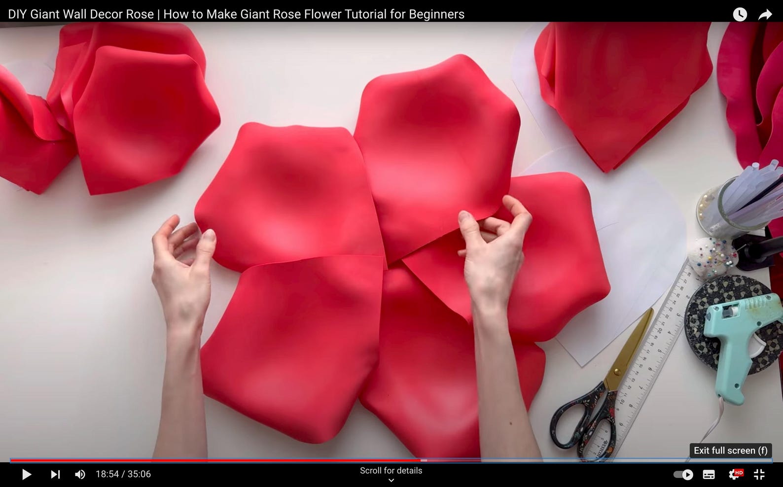 DIY Giant Rose Flower Tutorial for Beginners with red rose petals and hands working on a white surface.