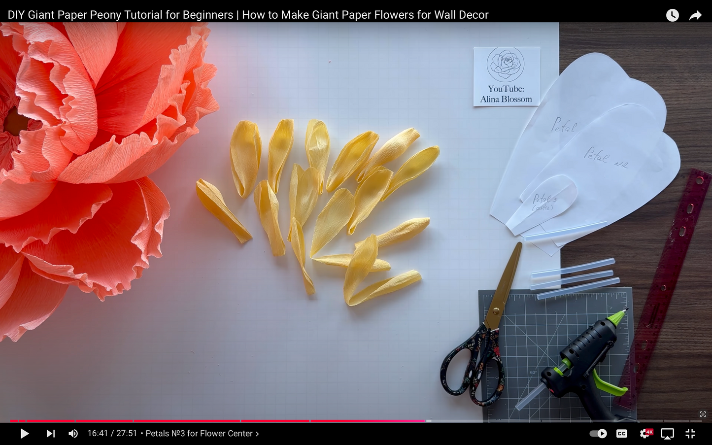 DIY Giant Paper Peony Tutorial for Beginners with paper flowers, scissors, and tools on a table.