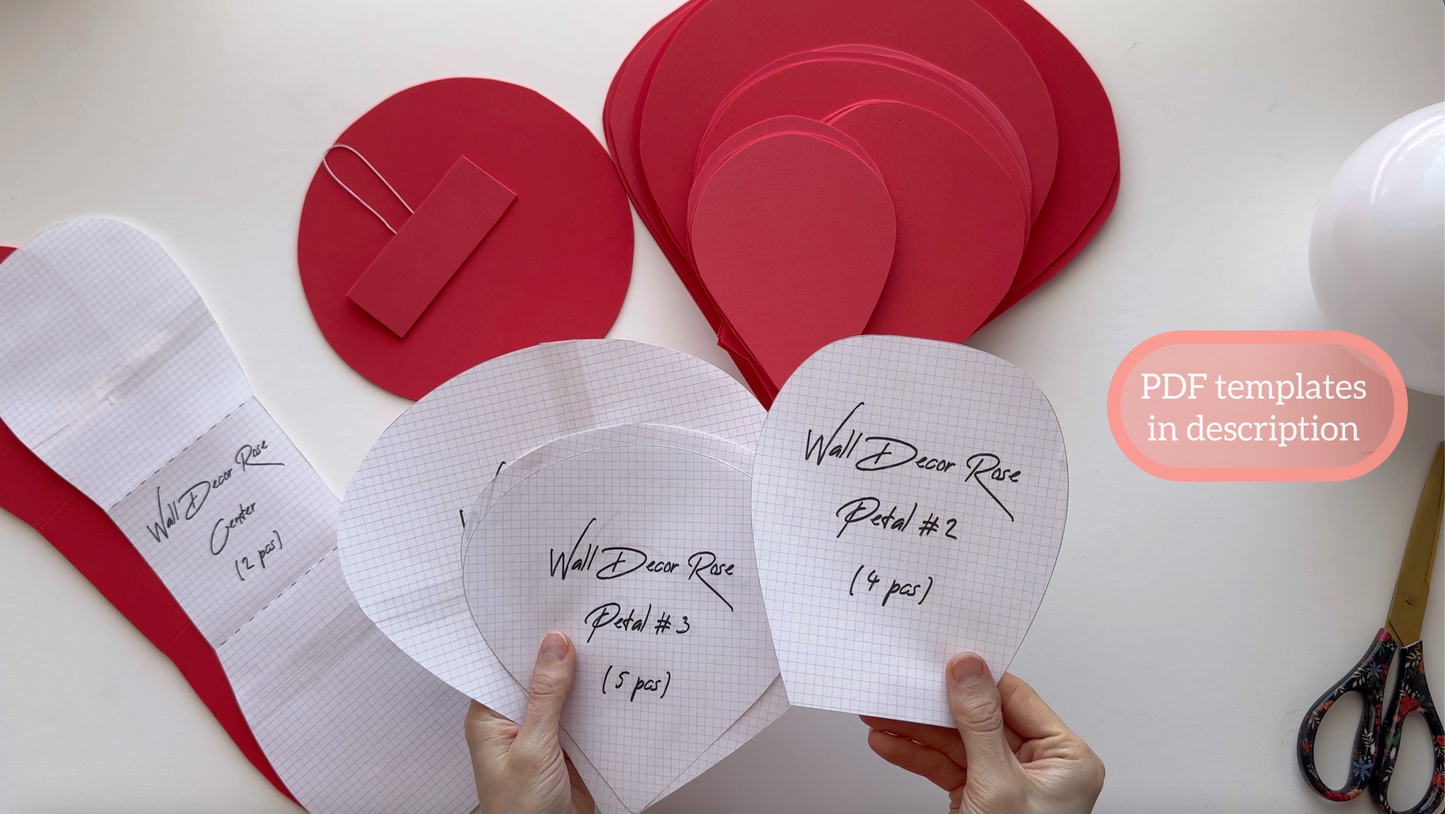 Hands holding paper cutouts with text and red circular cutouts on a white background.
