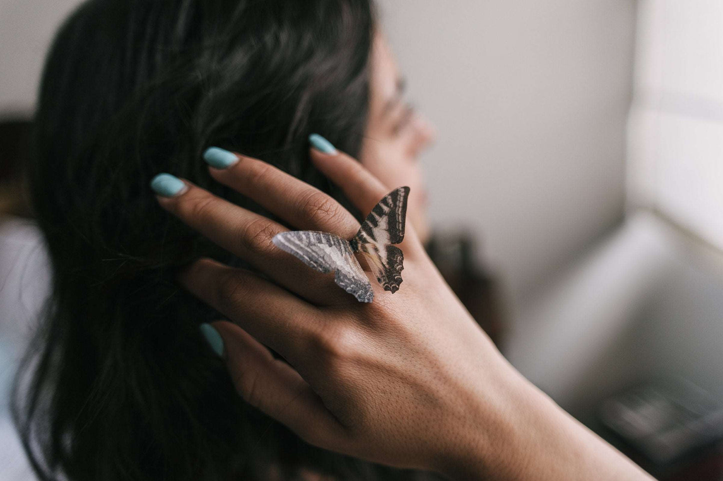 Black and white butterfly ring on finger