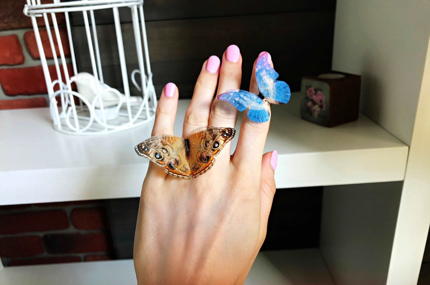 Brown and blue butterfly ring on a hand