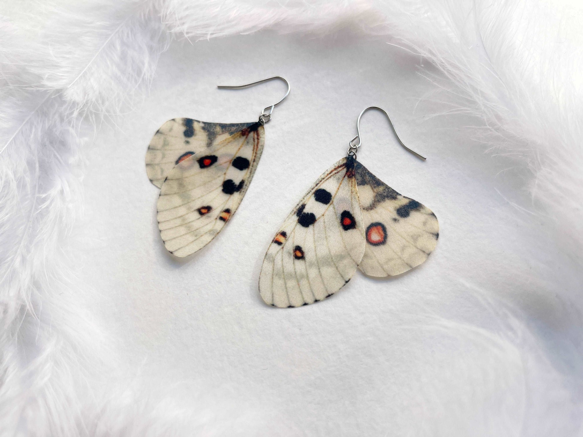 Ivory butterfly wing earrings on a white background