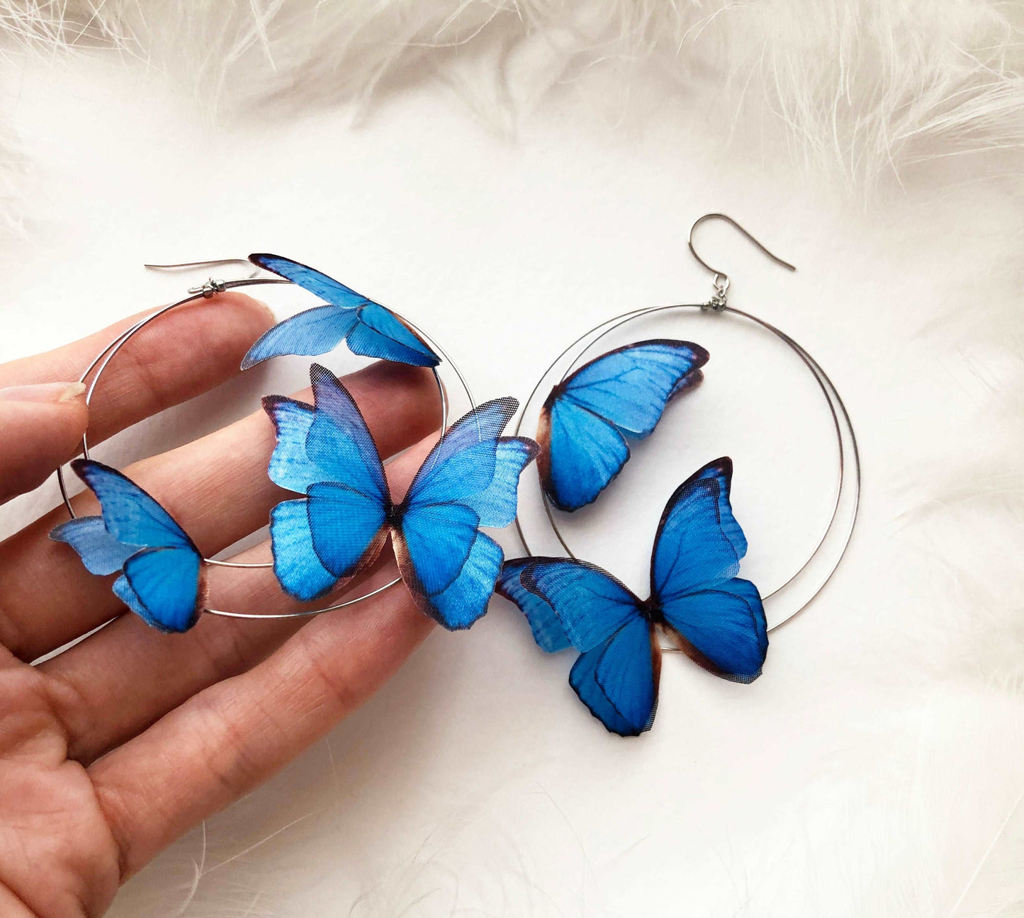 Close-up of handmade Gunmetal color Hoop Earrings with delicate blue butterfly charms, perfect for adding a pop of color to any outfit