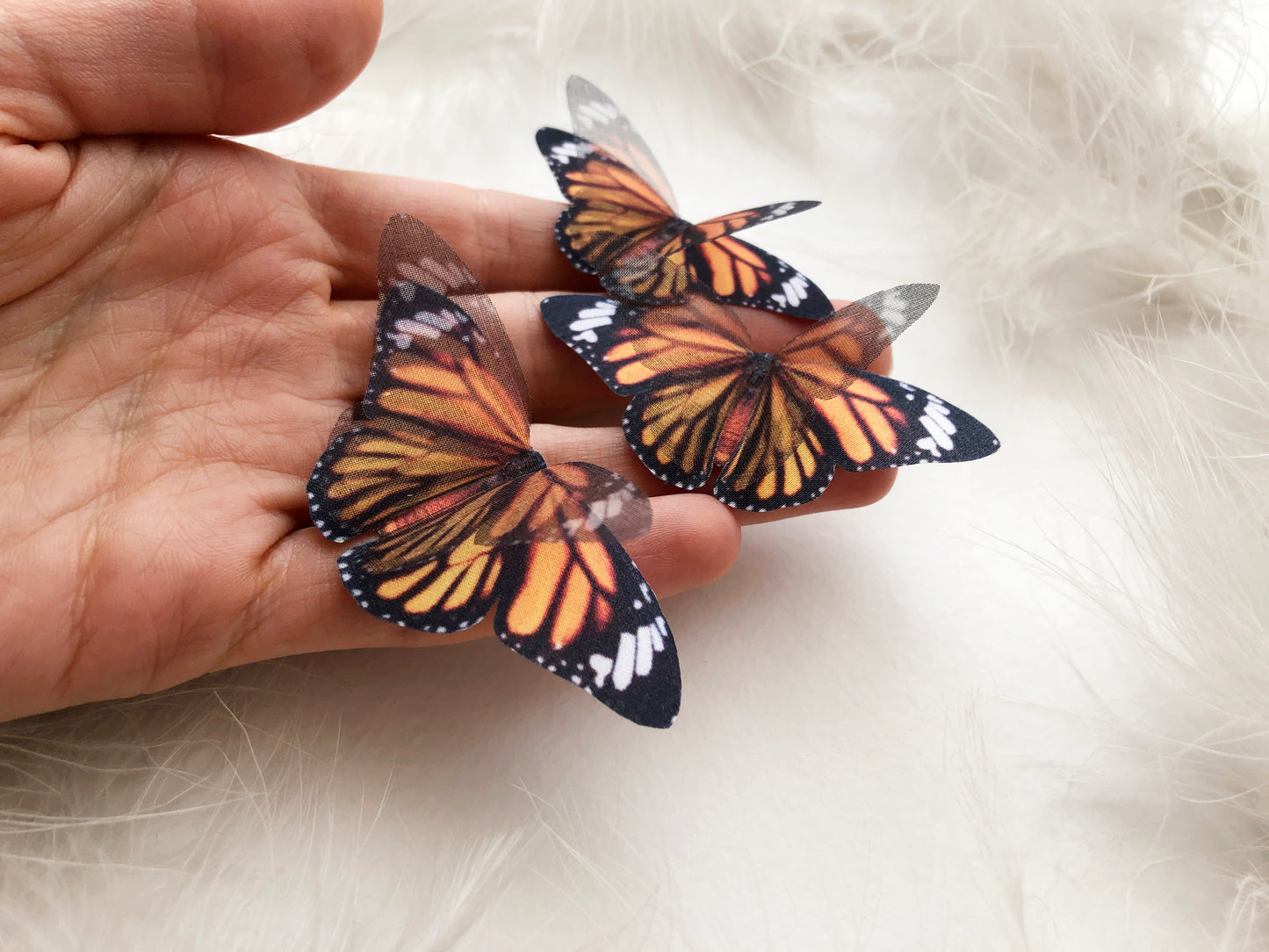 3 Monarch Butterflies on a Hand White Background
