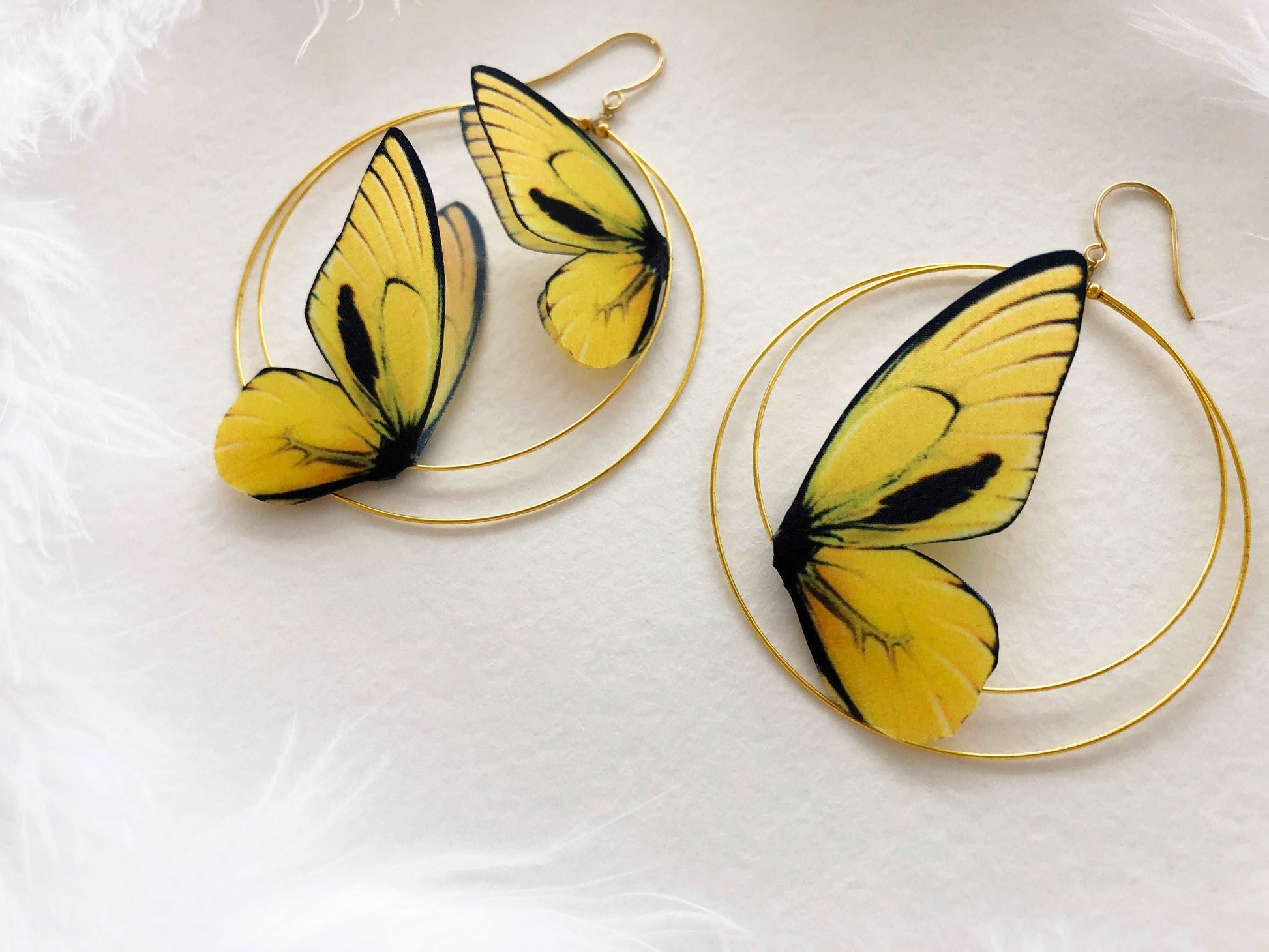 Hoop Earrings with Yellow Butterflies on White Background and Feathers