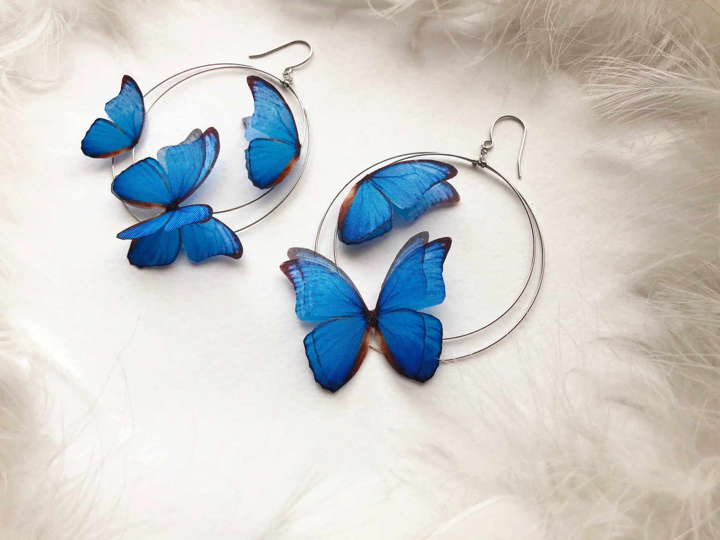 silver color Hoop Earrings featuring vibrant blue butterfly charms, handmade by a skilled crafter using high-quality materials