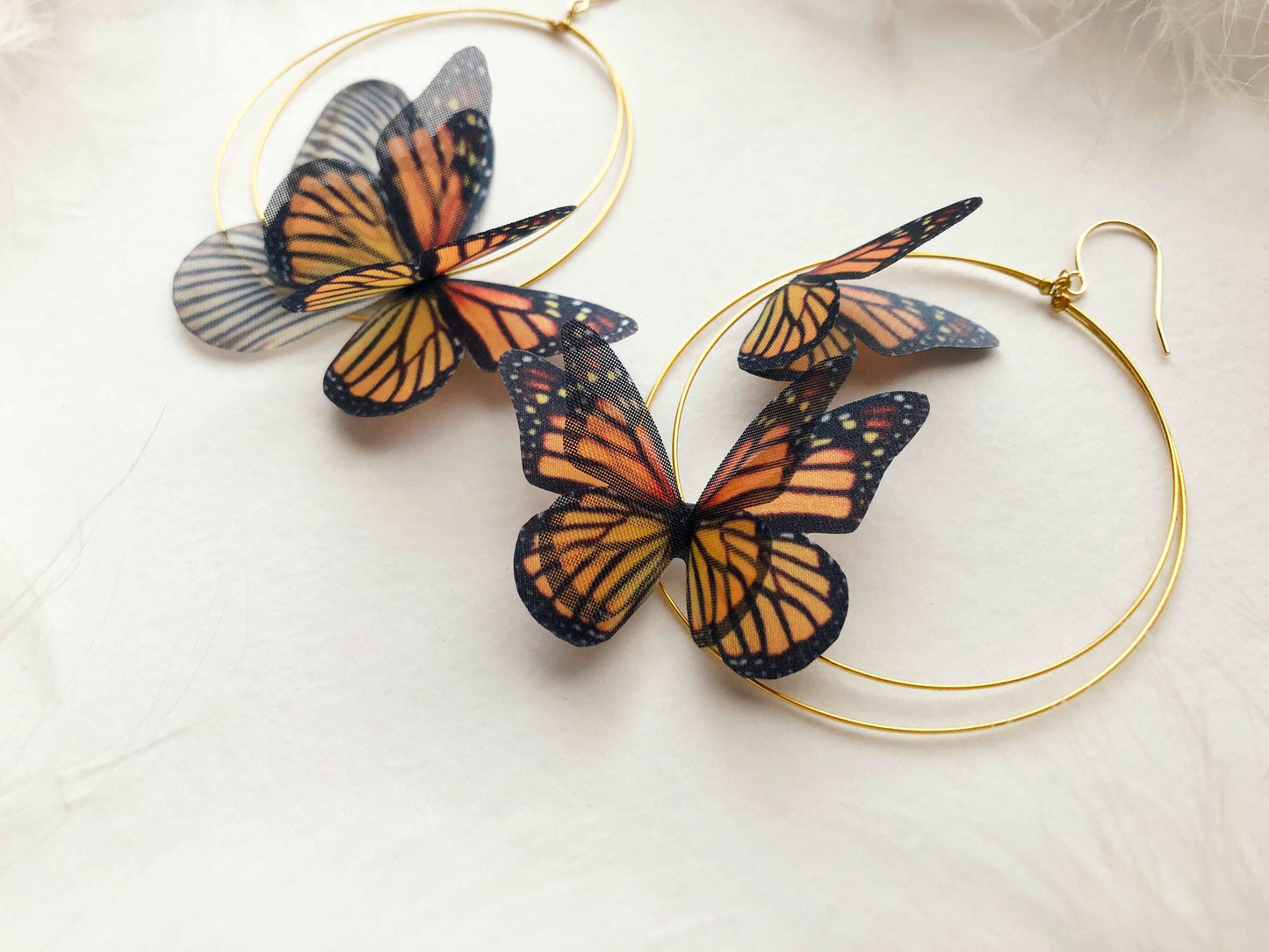 Detailed view of the gold-tone hoop on the Monarch Butterfly Hoop Earrings