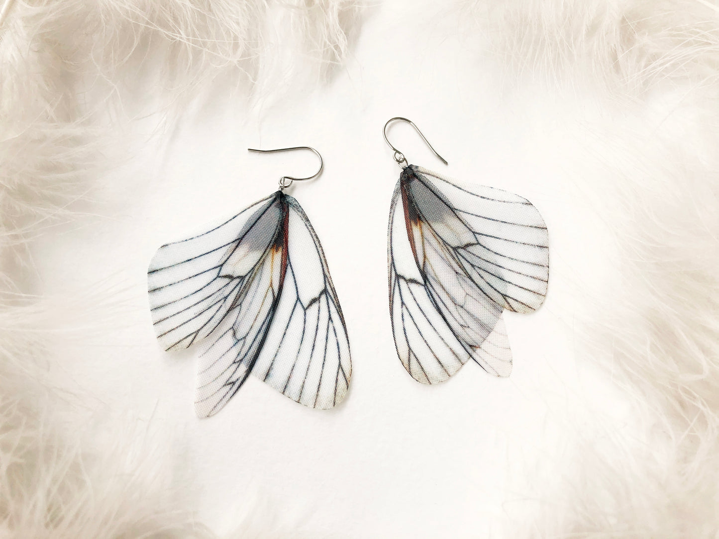 Off-white fairy earrings with dangling wings