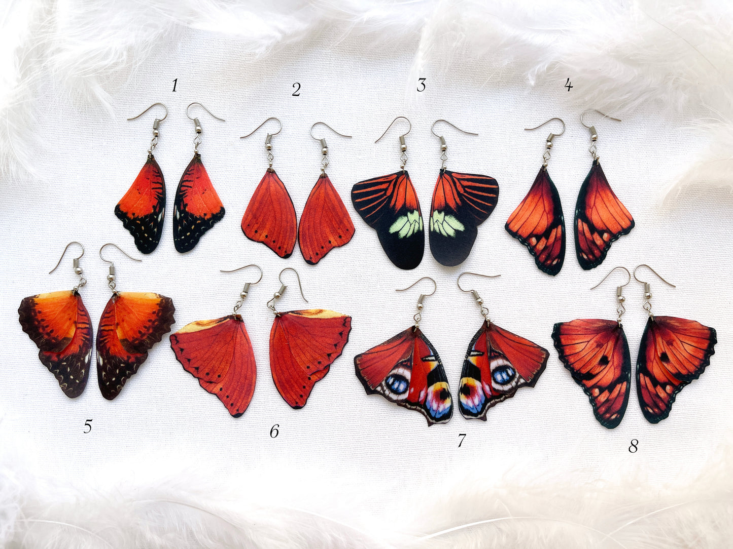 Bright Red Butterfly Earrings on White Background with FeathersRuby Red Butterfly Wing Earrings on display