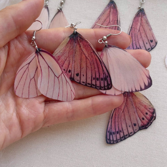 Pink Butterflies Earrings on Beige Background with White Feathers