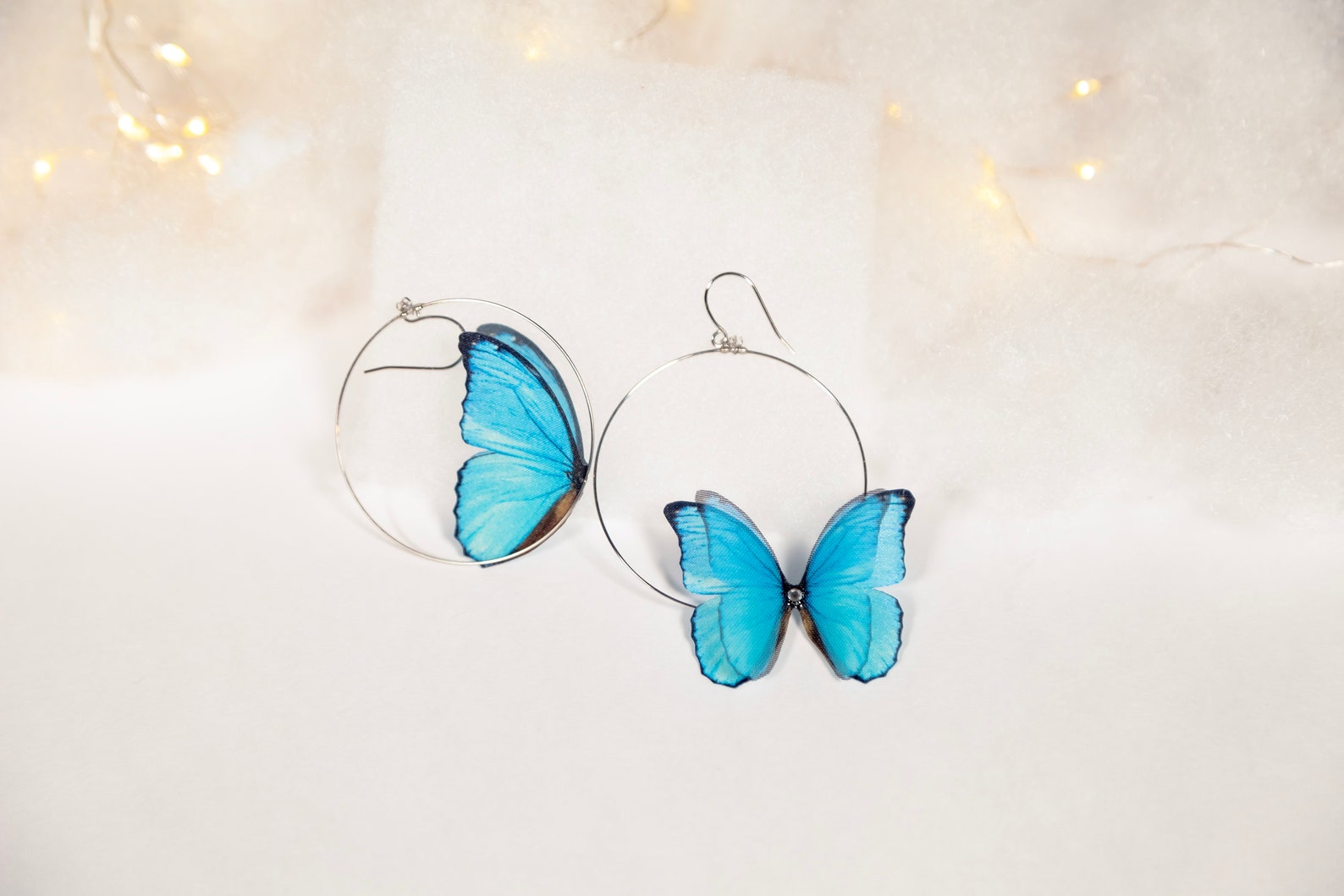 Blue Butterfly Hoop Earrings with Intricate Details on White Background
