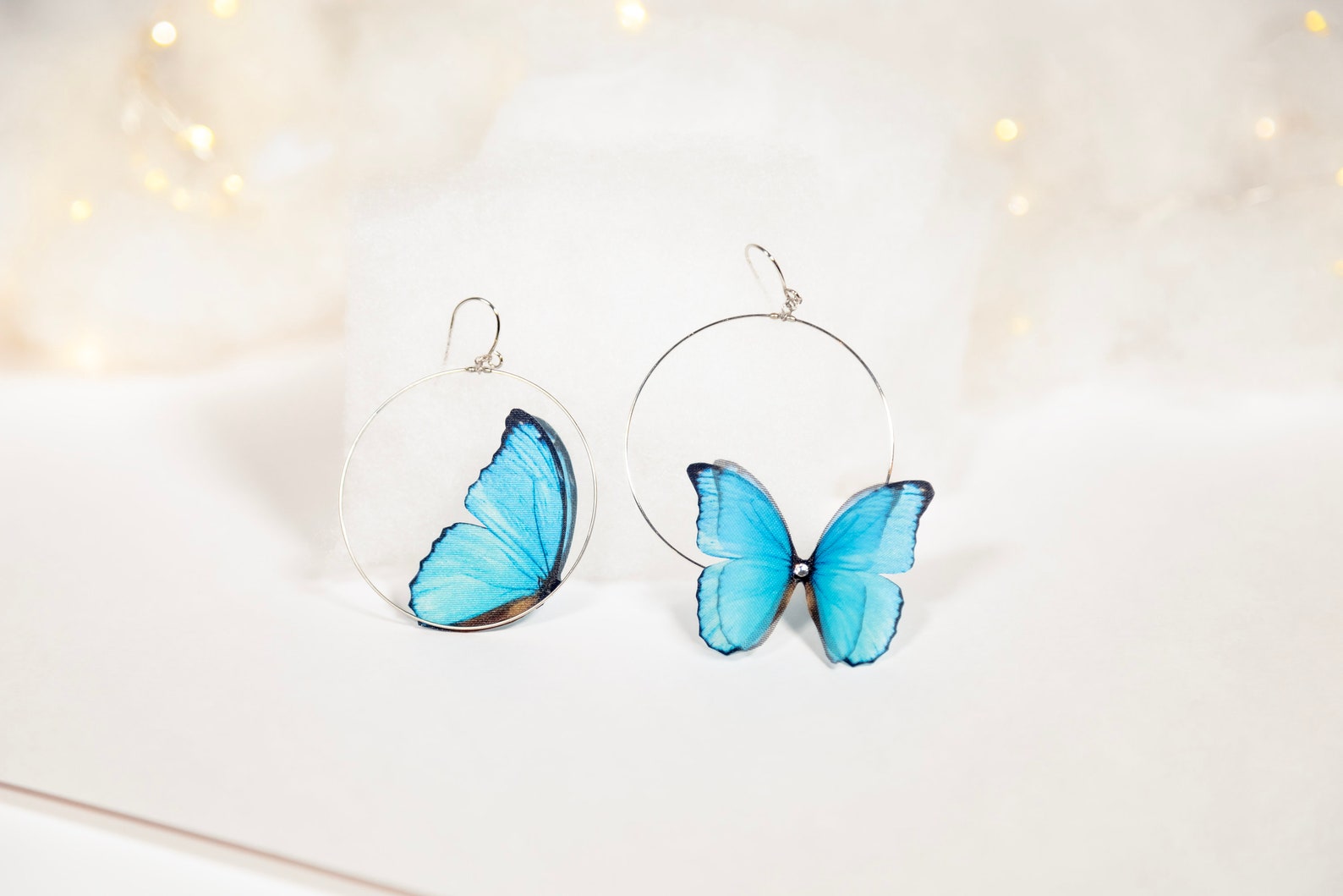 Close-up of Blue Butterfly Hoop Earrings on White Background