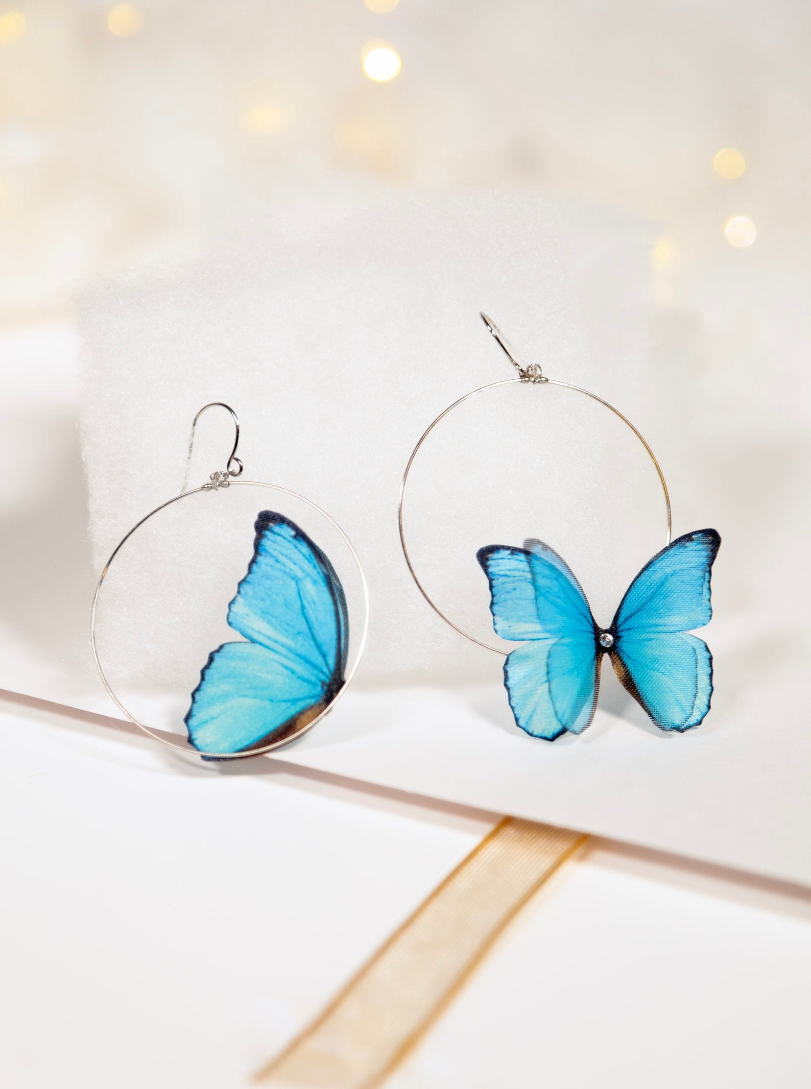 Blue Butterfly Hoop Earrings with Delicate Beading on White Background