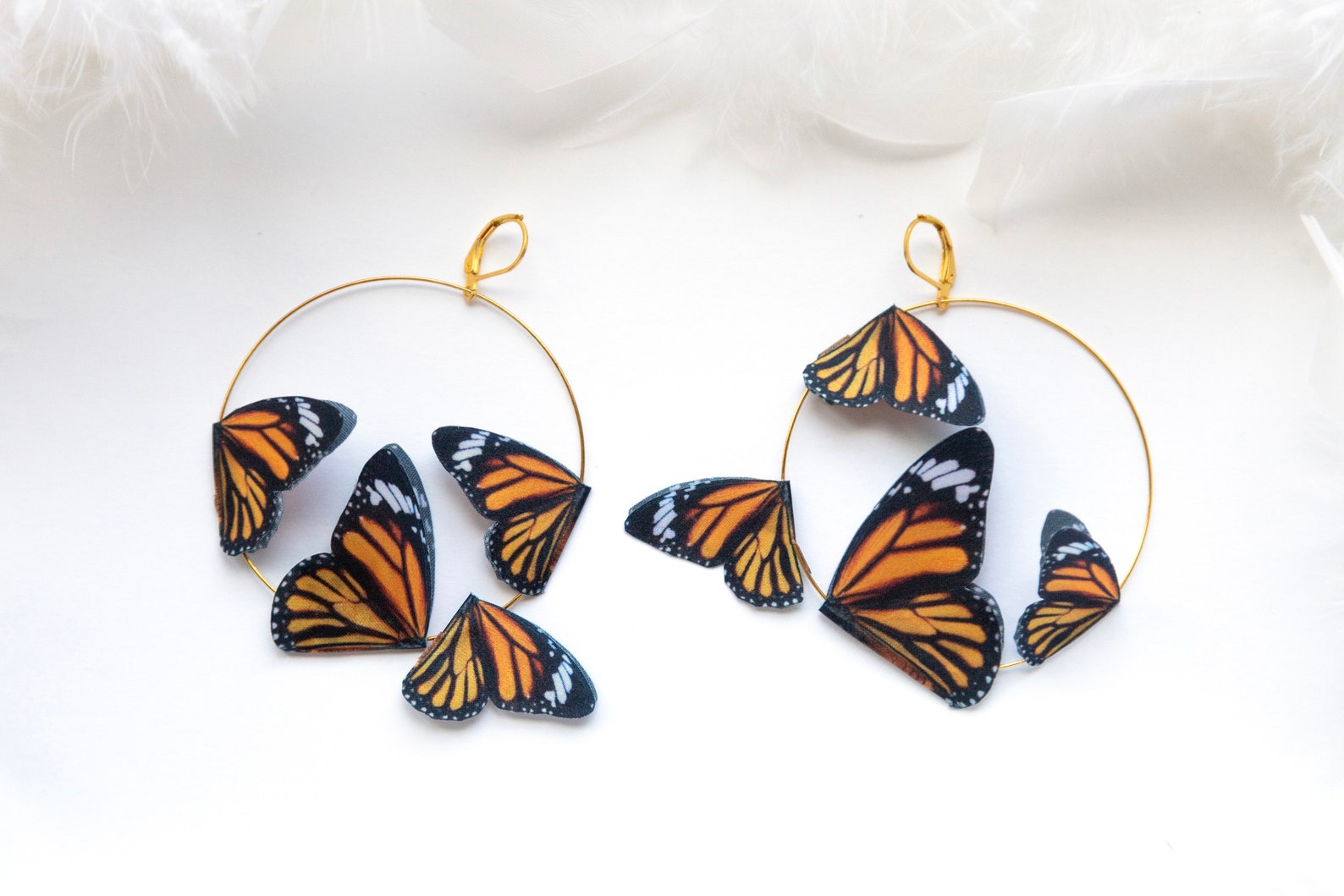 Gold hoop earrings with delicate monarch butterfly charms