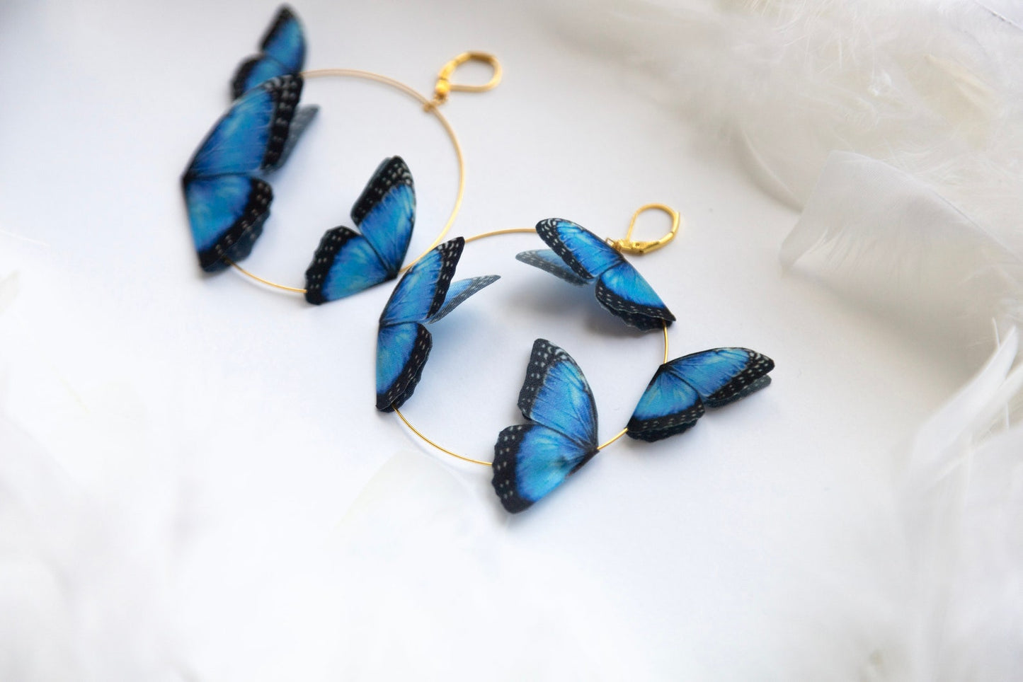 Hypoallergenic gold hoops with delicate blue butterfly wing charms