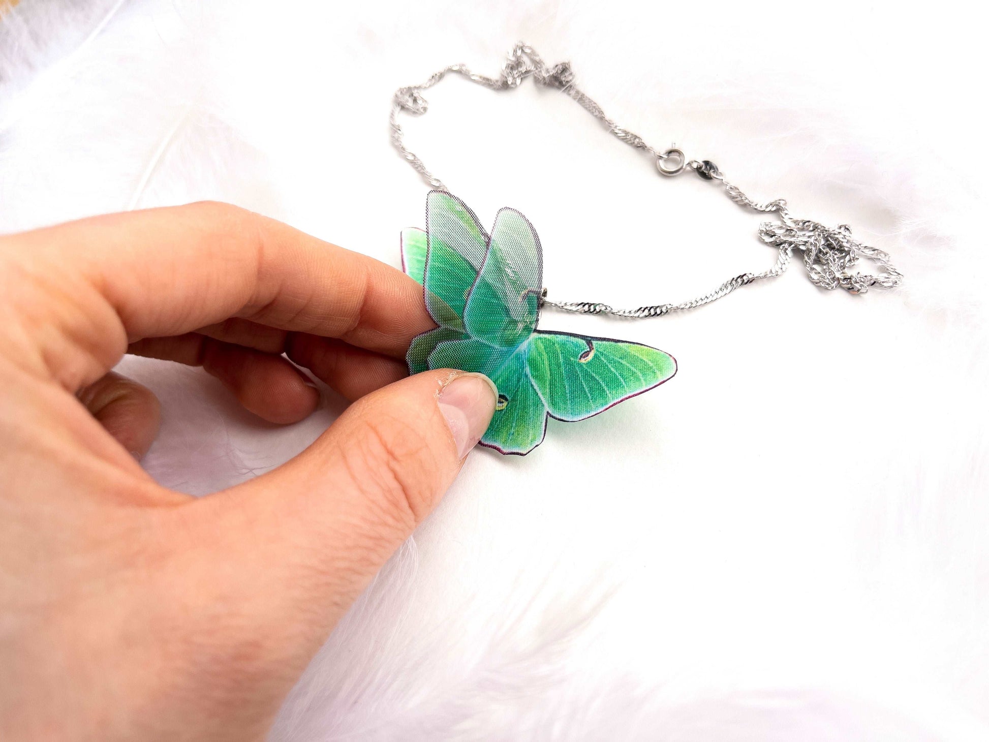 Green Lunar Moth Pendant on a mannequin bust - Add a boho touch to your outfit with this unique piece of jewelry