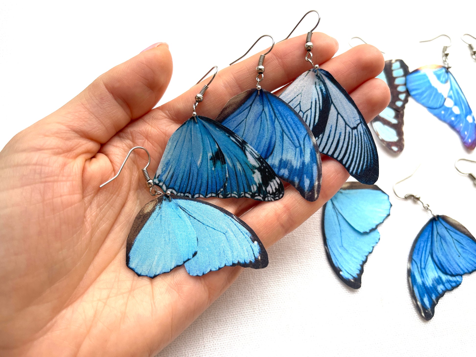 Detailed shot of butterfly wings earrings in cobalt blue